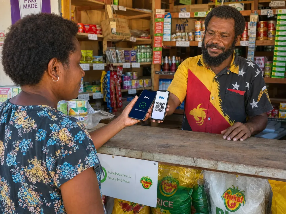 Customer scanning the QR code on a shopkeeper’s phone with the PIN app, payment successful shown on her phone